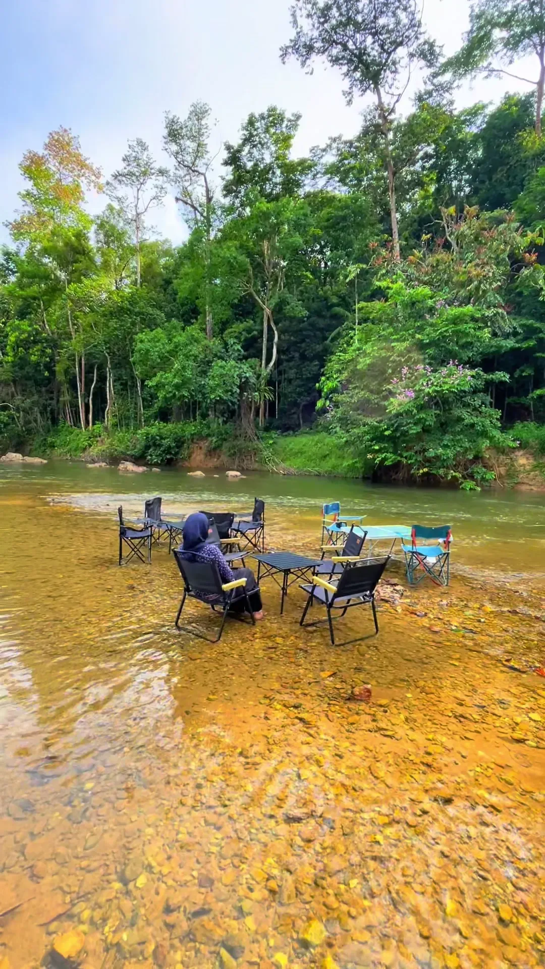 Kerusi dan meja di dalam sungai jernih Barouk Hut, berlatarkan hutan